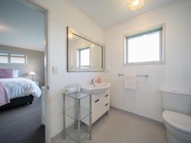 A bathroom with a sink, mirror, and toilet at Te Anau