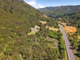 A house near a road surrounded by trees and fields at Hill Cottage - Featherston Holiday Home, Featherston