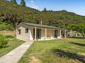 A house with a lawn and pathway at Hill Cottage - Featherston Holiday Home in Featherston