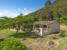 An outdoor area with a house and tree at Hill Cottage - Featherston Holiday Home Featherston