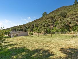 A house with trees and a mountain in the background at Hill Cottage - Featherston Holiday Home, Featherston