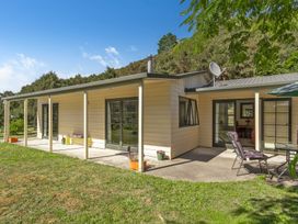 An outdoor view of a house with patio and garden at Hill Cottage - Featherston Holiday Home in Featherston