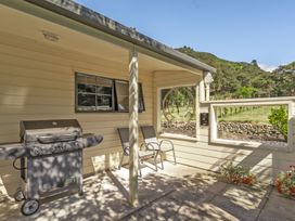An outdoor patio with a grill and seating at Hill Cottage - Featherston Holiday Home, Featherston