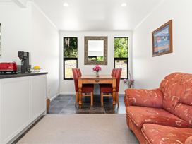 A kitchenette with a dining table and chairs at Hill Cottage - Featherston