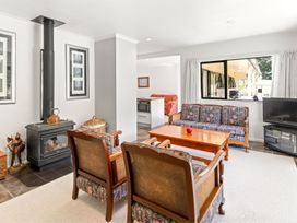 A living room with a wood stove and seating at Hill Cottage - Featherston Holiday Home in Featherston