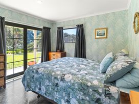 A bedroom with a bed and window at Hill Cottage - Featherston