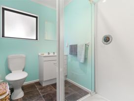 A bathroom with a shower and a toilet at Hill Cottage - Featherston Holiday Home