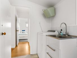 A laundry room with a washing machine and sink at Waihi Beach Holiday Home, Waihi Beach