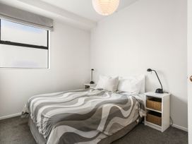 A bedroom with a bed and nightstands at Waihi Beach Holiday Home Waihi Beach