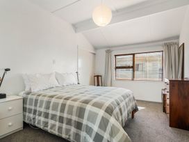 A bedroom with a bed and window at Waihi Beach Holiday Home in Waihi Beach