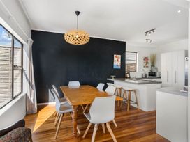 A dining room with a table and chairs at Waihi Beach Holiday Home in Waihi Beach