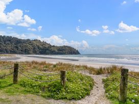 A beach with a path leading to the water at Waihi Beach Holiday Home in Waihi Beach