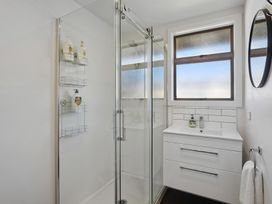A bathroom with a shower, sink, and mirror at Antimony Retreat - Cromwell Holiday Home, Cromwell