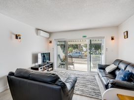 A living room with a sofa and TV at Sea-renity - Napier Holiday Home Napier South