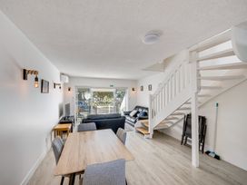 A living room with a sofa, table, and chairs at Sea-renity - Napier Holiday Home in Napier South