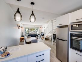A kitchen with a refrigerator and stove at Sea-renity - Napier Holiday Home Napier South