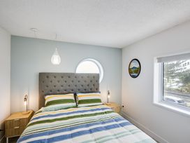 A bedroom with a bed and bedside table at Sea-renity - Napier Holiday Home in Napier South