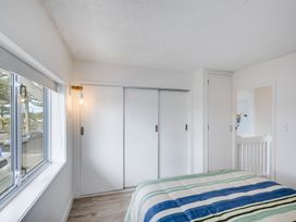 A bedroom with a bed and window at Sea-renity - Napier Holiday Home Napier South