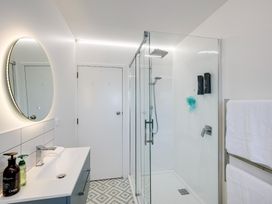 A bathroom with a shower, mirror and sink at Sea-renity - Napier Holiday Home Napier South