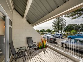 A balcony with chairs and a flower pot at Sea-renity - Napier Holiday Home in Napier South