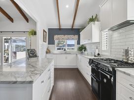 A kitchen with cabinets, countertop, stove, and sink at the property