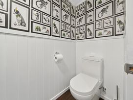 A bathroom with a toilet and patterned wall art