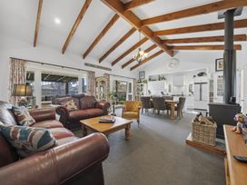 A living room with a sofa, armchair, coffee table, and dining area at the property