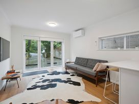 A living room with a sofa and television at Cosy Studio Retreat - Wellington