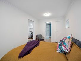 A bedroom with a bed and chair at Cosy Studio Retreat - Wellington