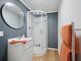 A bathroom with a shower and a vanity at Cosy Studio Retreat - Wellington