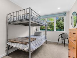 A bedroom with a bunk bed and a single bed at Taotahi Hideaway - Ruakaka