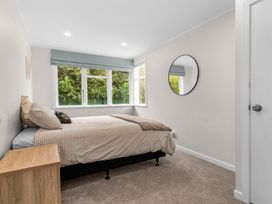 A bedroom with a bed and window at Taotahi Hideaway - Ruakaka Holiday Home in Ruakaka
