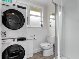 A bathroom with washer and dryer in Taotahi Hideaway - Ruakaka