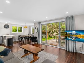 A living room with a television and dining area at Taotahi Hideaway - Ruakaka