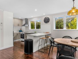 A kitchen with a stove and refrigerator at Taotahi Hideaway - Ruakaka