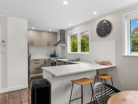 A kitchen with cabinets and a stove at Taotahi Hideaway - Ruakaka