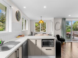 A kitchen with a sink and a microwave at Taotahi Hideaway - Ruakaka Holiday Home Ruakaka