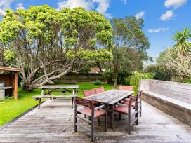 A garden with a table and chairs at Taotahi Hideaway - Ruakaka
