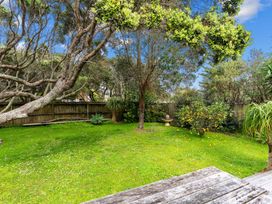 A garden with trees and a birdbath at Taotahi Hideaway - Ruakaka