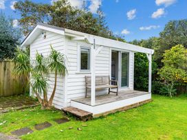 A cabin with a bench on the deck at Taotahi Hideaway - Ruakaka