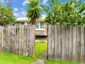 A wooden fence with a pathway leading to a house at Taotahi Hideaway - Ruakaka