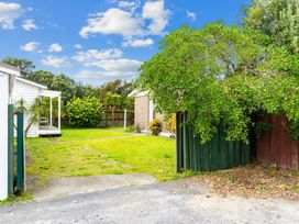 A garden area with a green lawn and a path at Taotahi Hideaway - Ruakaka