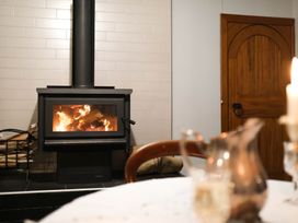 A fireplace with logs and a candle at Dunluce Coastal Farmstay - Kaikoura Holiday Home Kaikoura