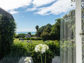 A view of the garden and sea from a window at Dunluce Coastal Farmstay - Kaikoura Holiday Home Kaikoura
