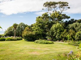 A garden with grass, trees, and shrubs at Dunluce Coastal Farmstay - Kaikoura