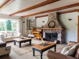 A living room with a fireplace and piano at Dunluce Coastal Farmstay - Kaikoura Holiday Home
