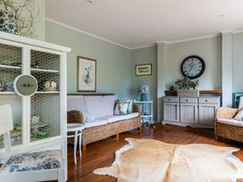 A living room with a sofa and armchair at Dunluce Coastal Farmstay - Kaikoura Holiday Home