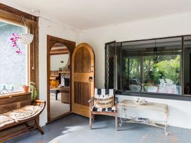 A porch area with a bench, table, and plants at Dunluce Coastal Farmstay - Kaikoura