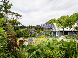 A garden with flowers and a house at Dunluce Coastal Farmstay - Kaikoura Holiday Home Kaikoura