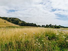 A landscape with mountains and grass along a road at Dunluce Coastal Farmstay - Kaikoura